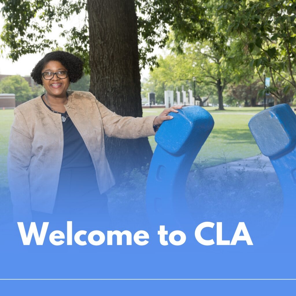 Dean Lyons standing next to horseshoe statue